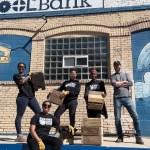 Tonika Garibaldi, Saj Dillard and other homeowners showing off planter boxes they made from recycled wood at the Baltimore ToolBank.