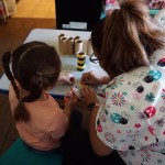 Maggi, a child care provider in New Mexico, works on an art project with a preschooler in her care.