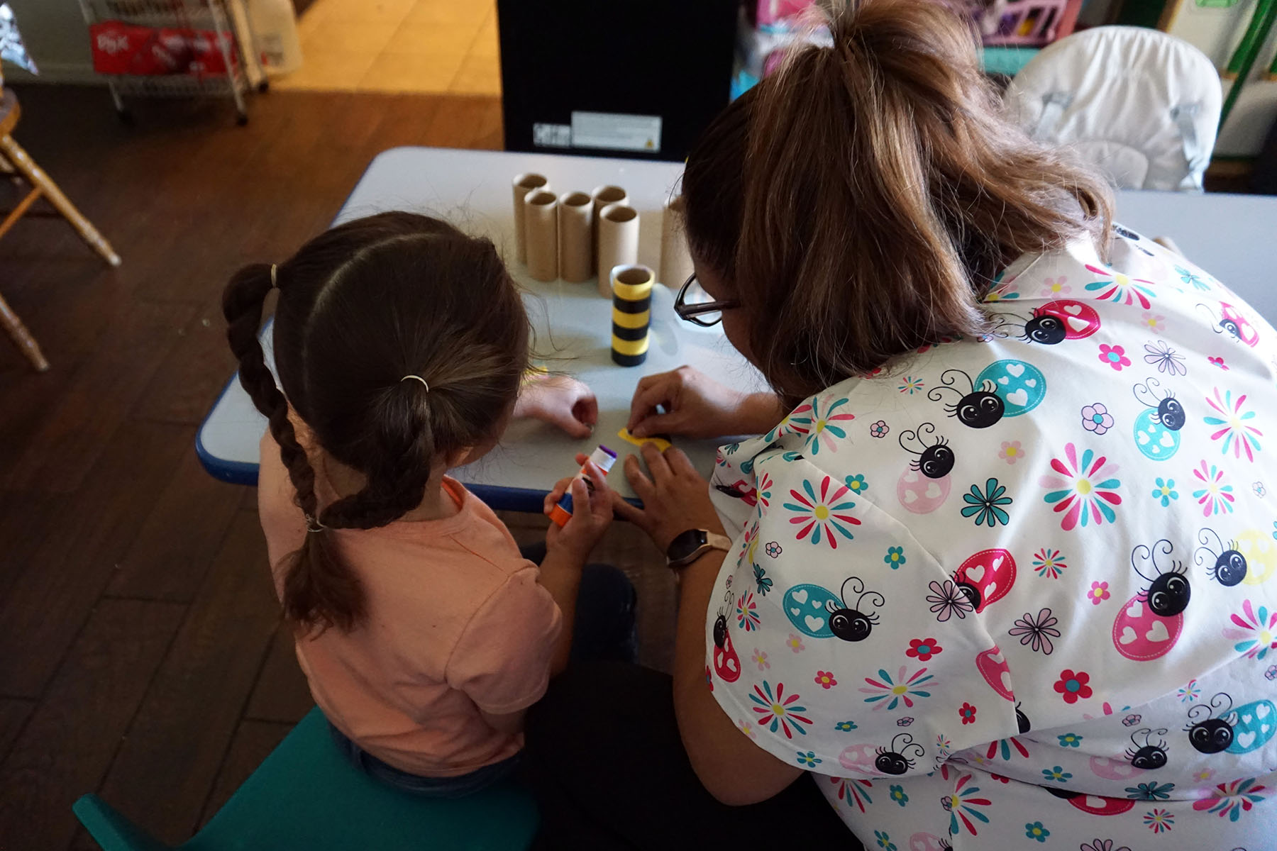 Maggi, a child care provider in New Mexico, works on an art project with a preschooler in her care.