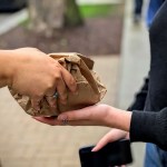 DePaul University student Maya Roman hands off a bag of condoms and other birth control to a volunteer.