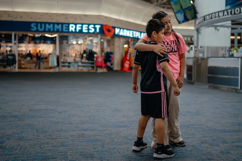 Elizabeth Guerra hugs family members at Milwaukee Mitchell International Airport before leaving for El Salvador.