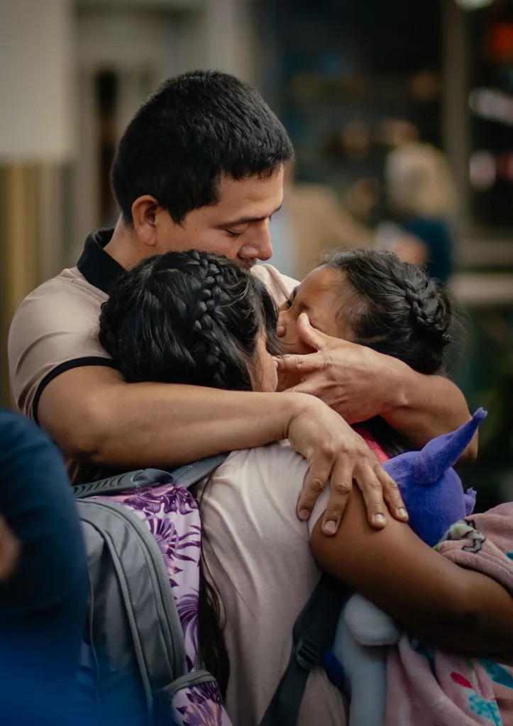 Miguel Guerra embraces his 10-year-old twin daughters before they leave with their mother as she self-deports back to El Salvador.