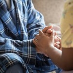 An image depicts two people holding hands.