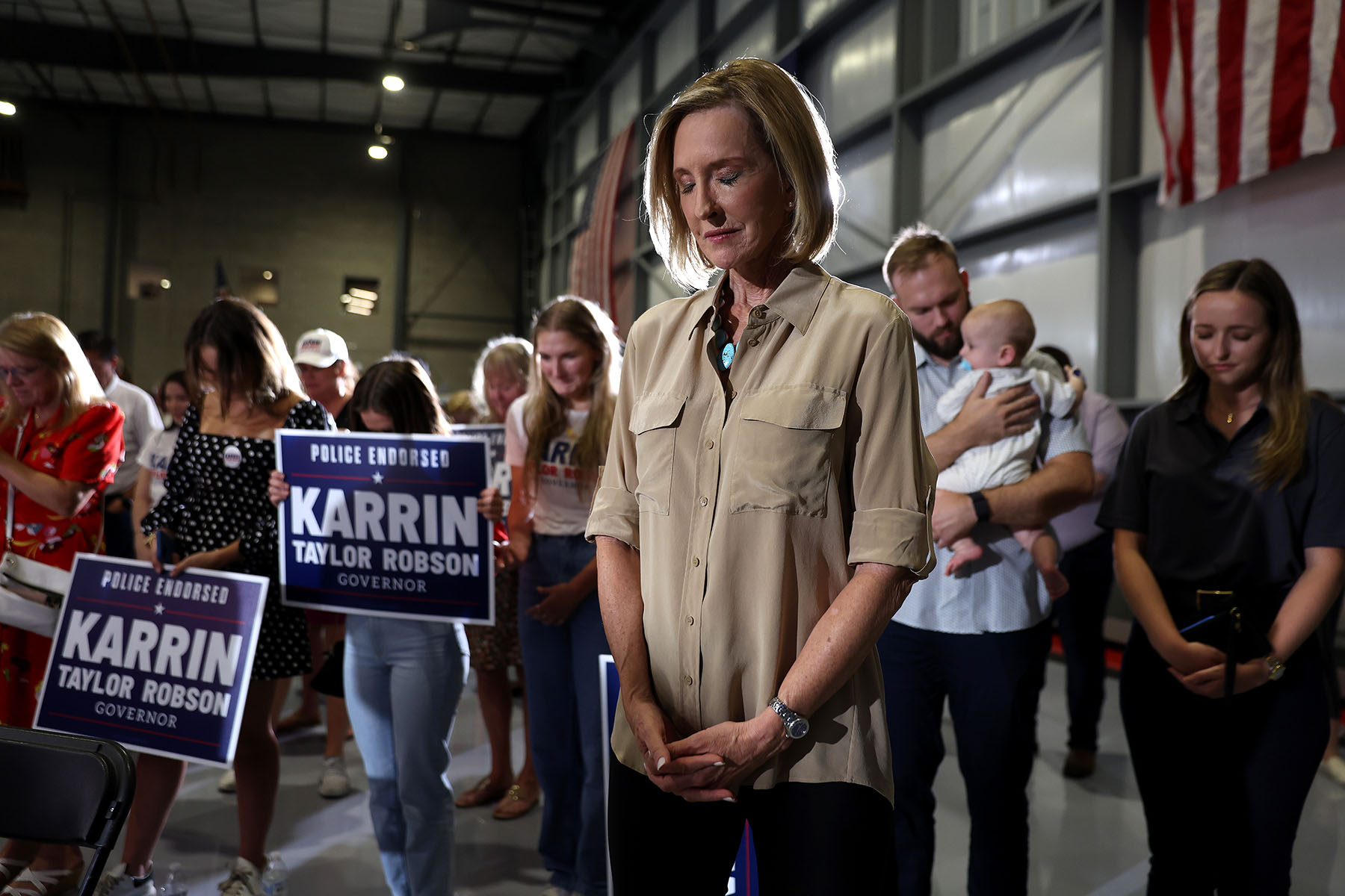 Karrin Taylor Robson pauses for prayer at a campaign rally.