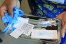 An immunization nurse carries a tray with a COVID-19 vaccine at Borinquen Health Care Center.