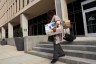 A Department of Education employee leaves the building with their belongings.