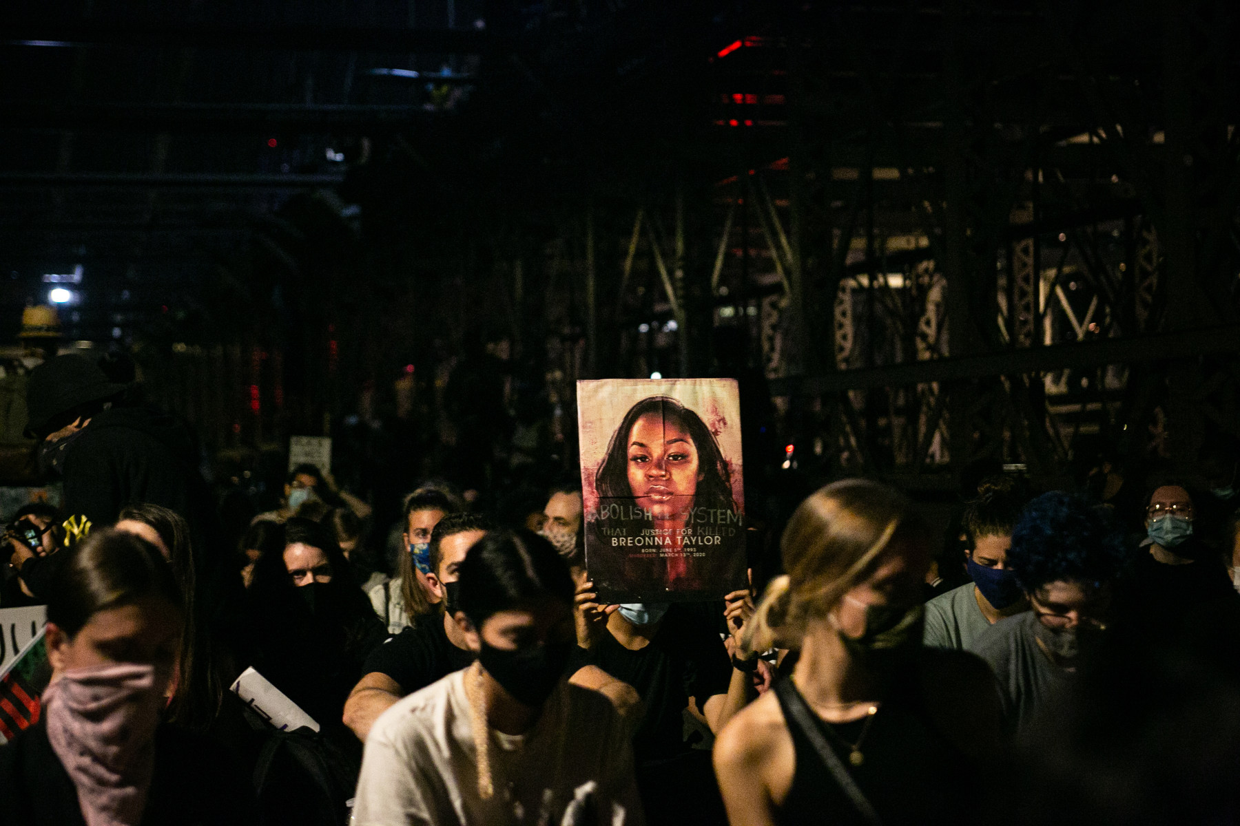 Protestors carry a sign showing Breonna Taylor's face.
