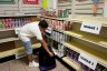 A child chooses protein items from the mochiladera storeroom at a nonprofit.
