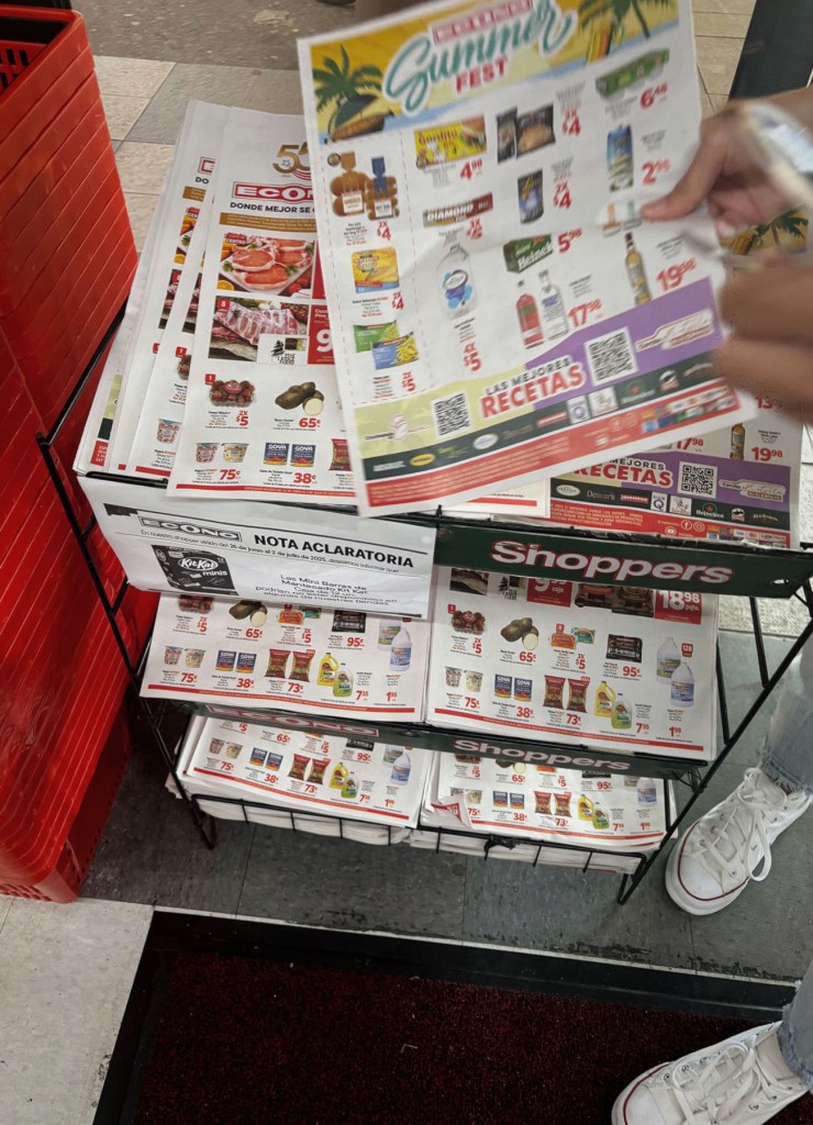 Shoppers sift through weekly deal pamphlets at Supermercados Econo in Campo Rico, Carolina, Puerto Rico.