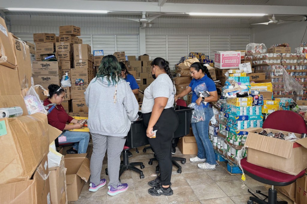 Volunteers sort through donations and provisions in a storeroom at Asociación Pro Juventud y Comunidad.
