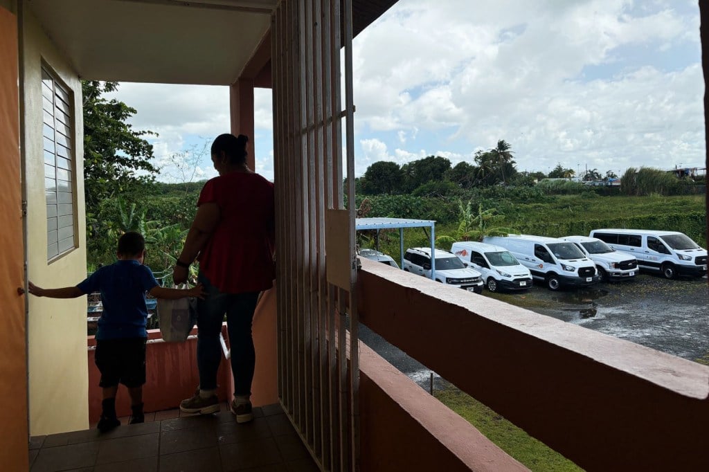 A mother and her son descend the stairs at the Asociación Pro Juventud in Cataño, Puerto Rico after receiving their provisions from the mochiladera program.