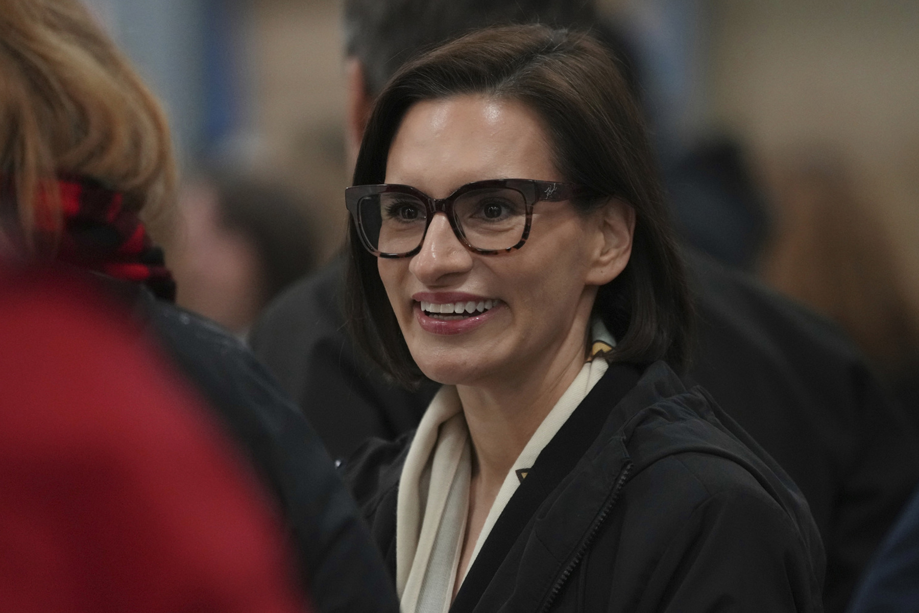 A woman smiles in a crowd.