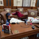 State Rep. Nicole Collier from Fort Worth sleeps at her desk on the Texas House floor.