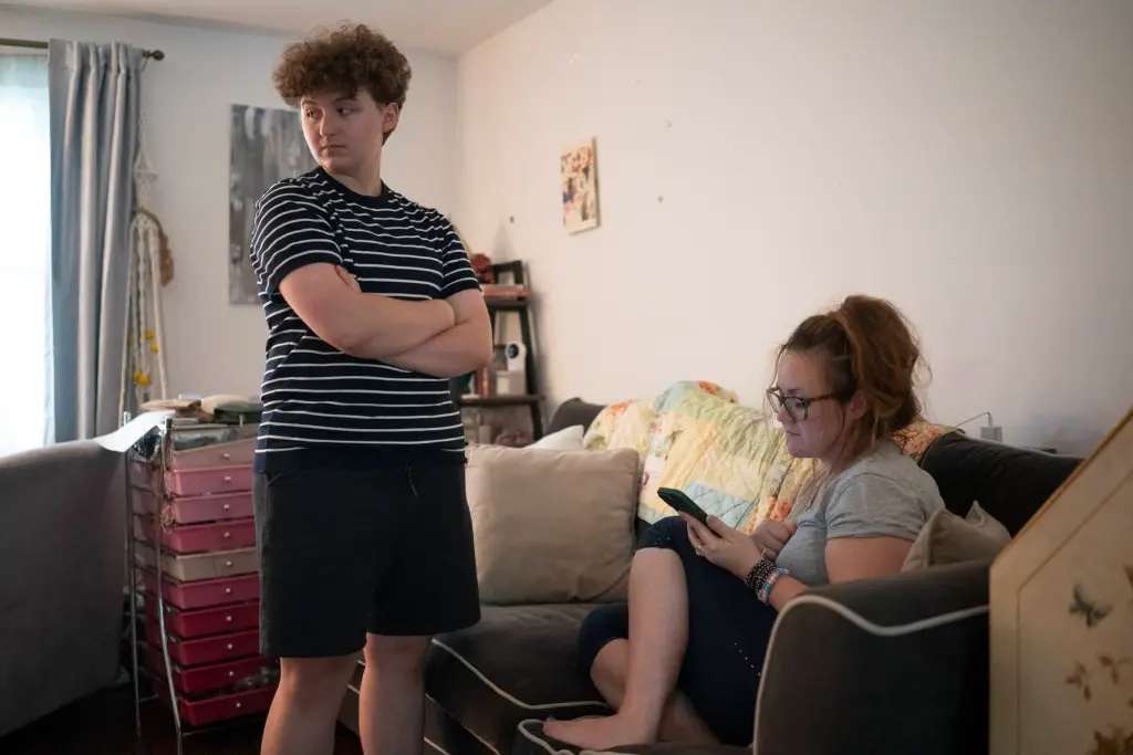 Lee (left) and Nicole listen to a Federal Trade Commission workshop titled, "the dangers of 'gender-affirming care’ for minors" in their living room.