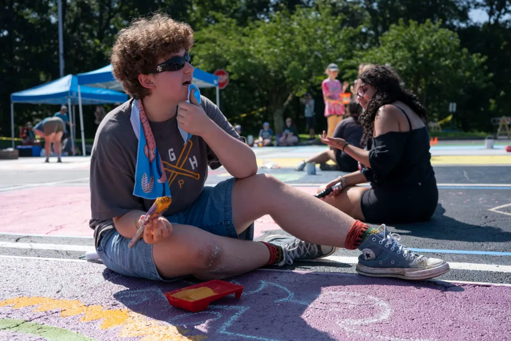 Lee paints a parking spot at Plum Senior High School with his friends.
