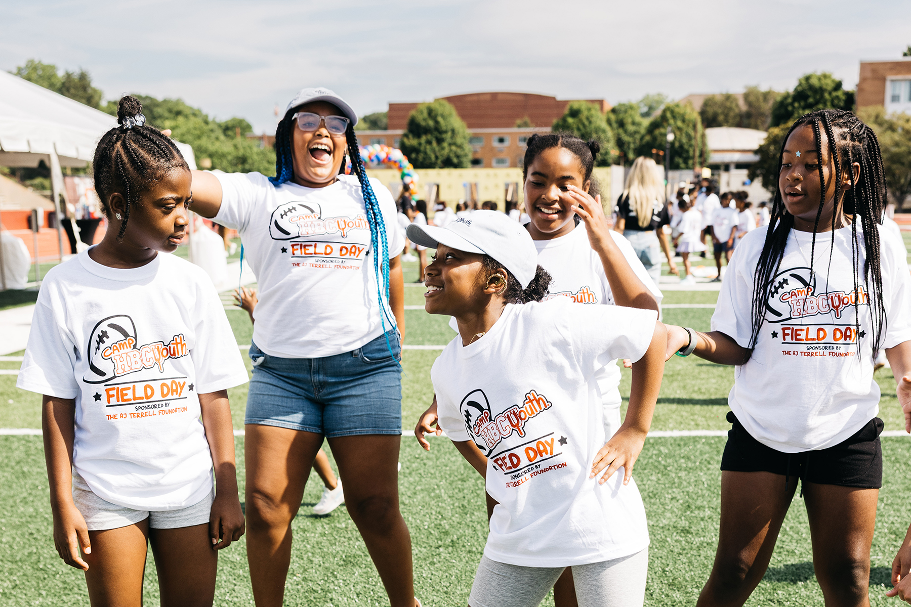 Five young girls play together on a field.