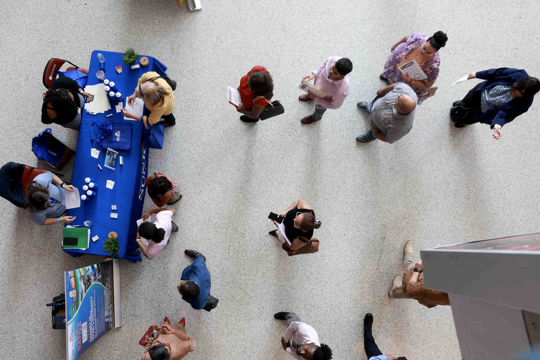 A view from above looking at lines of job seekers at a job fair.