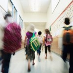 Children walk down a school hallway