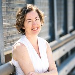 Smiling portrait of Jane Clougherty standing on an overpass.