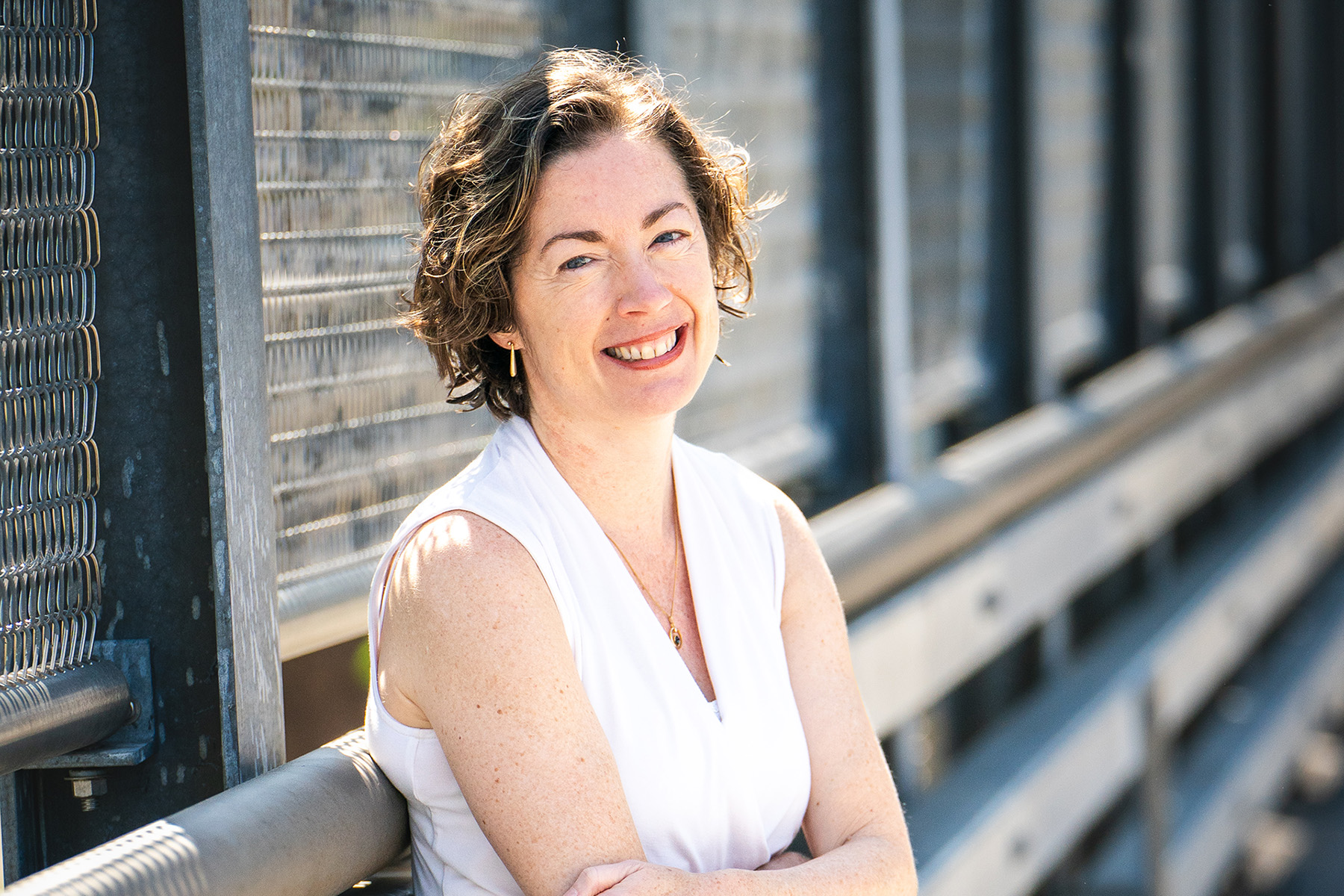 Smiling portrait of Jane Clougherty standing on an overpass.