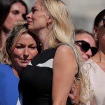 Two women embrace in a crowd of women.