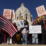 Anti-ICE Protestors wave flags and signs outside a Minneapolis government building.