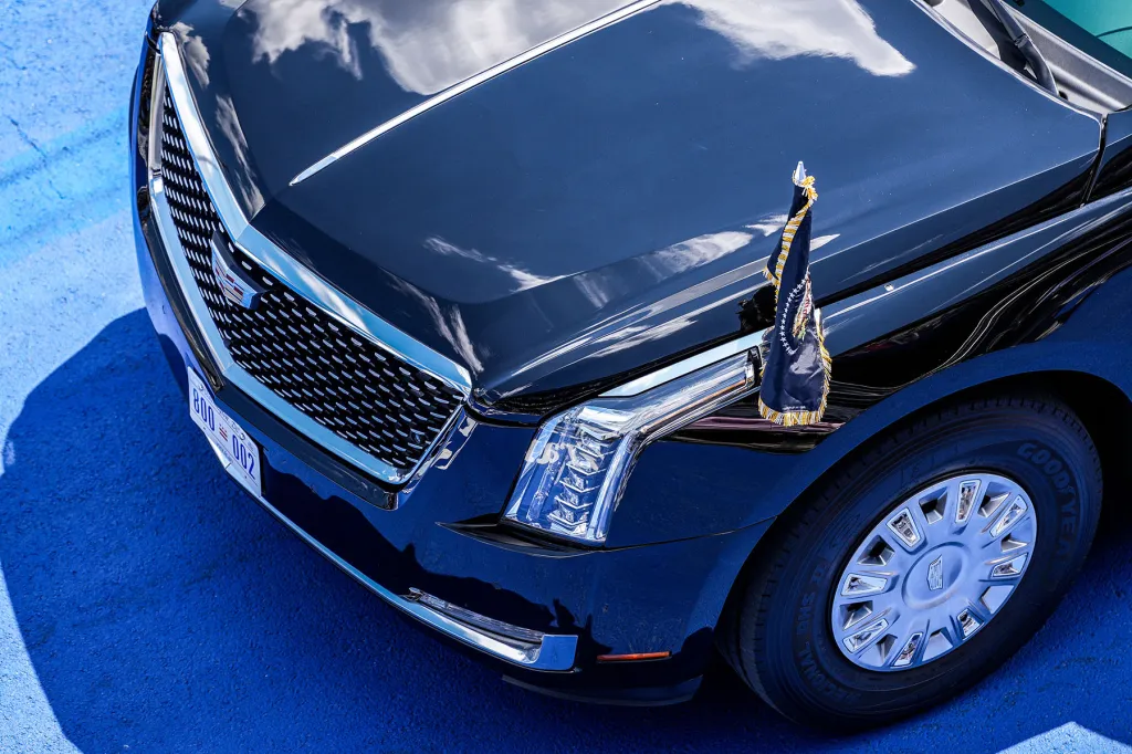 Close-up of a Cadillac limousine with a presidential flag mounted on the hood.