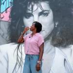 Florida state Rep. Angie Nixon drinks a Cuban coffee in front of a mural of singer Gloria Estefan on a tour of the Little Havana neighborhood in Miami.