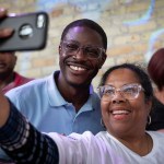 Democratic Wisconsin gubernatorial candidate David Crowley smiles as he takes a selfie with a supporter at a campaign rally.