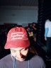 A person wears a red hat that says Democratic Socialists of Ameriac.