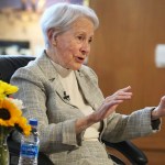 Kassebaum gestures while speaking and seated in a chair.
