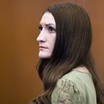 Clancy looks pensively off frame in the courtroom.