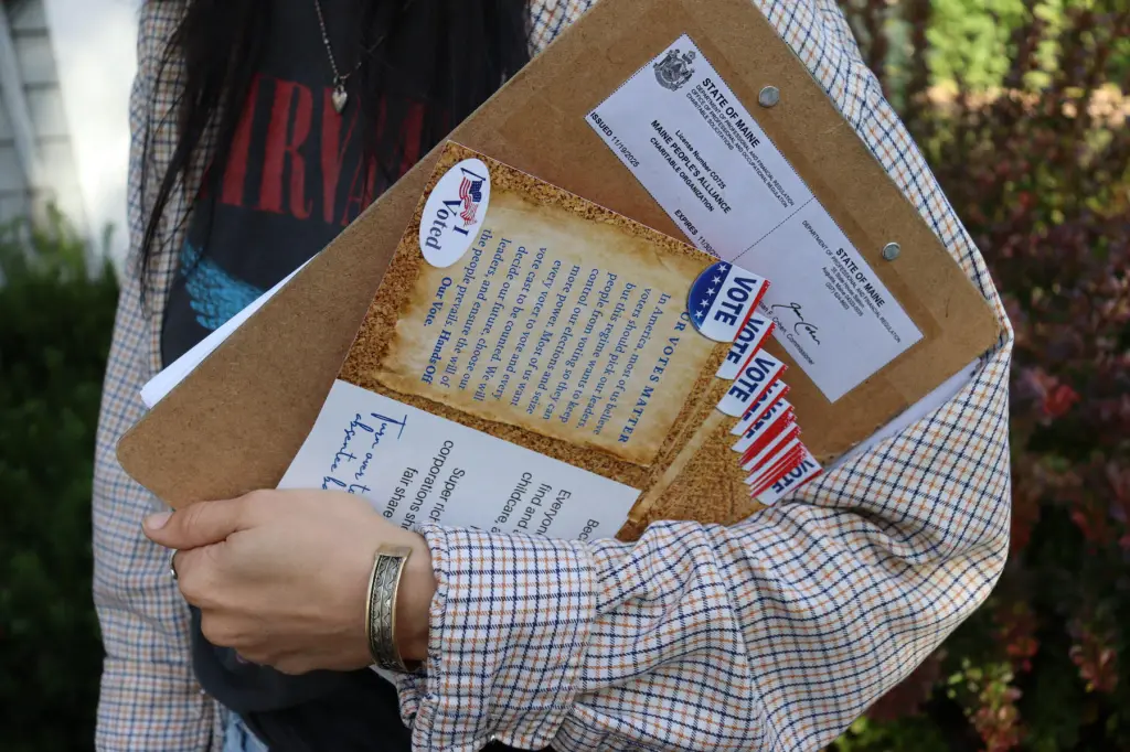 A closeup on a hand holding campaign materials.