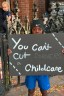 A child holds a protest sign on a street.