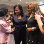 Bottoms speaks to three other women in the middle of a banquet hall.