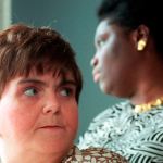 Two women look in opposite directions in closeup.